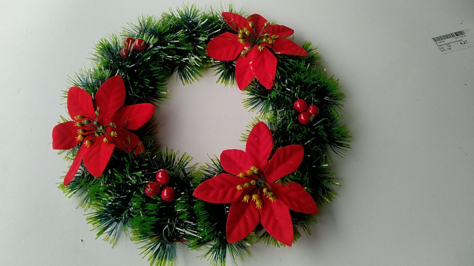 Grüner Weihnachtskranz mit roten Weihnachtssternen